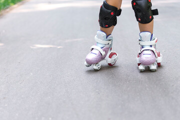 kid is rollerblading in the park. legs close up