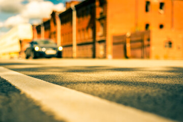 Summer in the city, the car driving on empty street. Close up view from the level of the dividing line