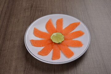 Chinese New Year festival colourful Yu Sheng Lo Hei salad with smoked salmon fish, cracker cookies and sweet sauce on wood background asian halal menu