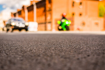 Summer in the city, the car and bike driving on empty street. Close up view  from the asphalt level