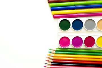 Colored pencils, paints and markers on a white background. School supplies