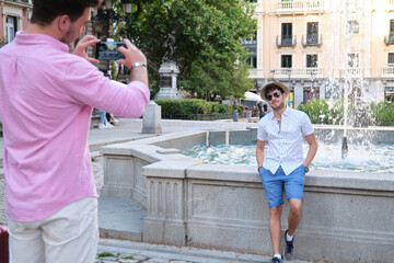 Man taking a picture of his partner at fountain.