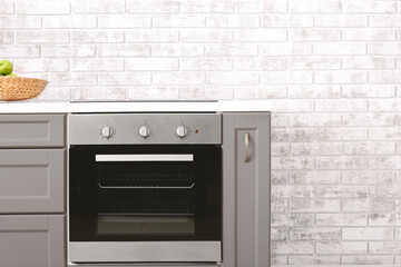 Fototapeta premium Modern kitchen counter with electric oven near brick wall