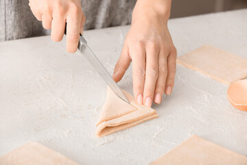 Woman preparing Danish pastry on kitchen table