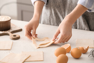 Woman preparing Danish pastry on kitchen table