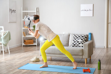 Young woman with virtual reality glasses playing tennis at home