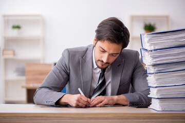 Young male employee unhappy with excessive work in the office