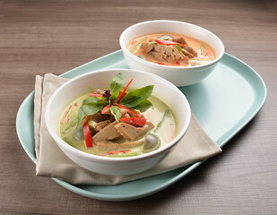 thai spicy chili red and green curry hot soup with vegetarian meat in bowl blue plate on wood background asian halal vegan menu