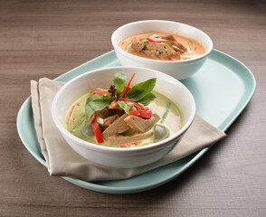 thai spicy chili red and green curry hot soup with vegetarian meat in bowl blue plate on wood background asian halal vegan menu