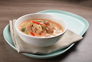 thai spicy chili red curry hot soup with vegetarian meat in bowl blue plate on wood background asian halal vegan menu