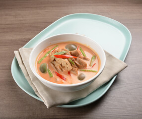 thai spicy chili red curry hot soup with vegetarian meat in bowl blue plate on wood background asian halal vegan menu