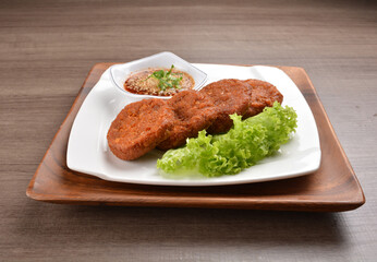 deep fried hash brown round potato cake with Thai spicy chilli sauce on wood background asian halal vegan menu