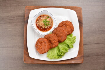 deep fried hash brown round potato cake with Thai spicy chilli sauce on wood background asian halal vegan menu