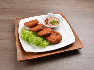 deep fried hash brown round potato cake with Thai spicy chilli sauce on wood background asian halal vegan menu