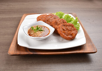 deep fried hash brown round potato cake with Thai spicy chilli sauce on wood background asian halal vegan menu