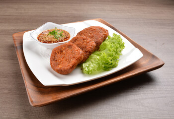 deep fried hash brown round potato cake with Thai spicy chilli sauce on wood background asian halal vegan menu