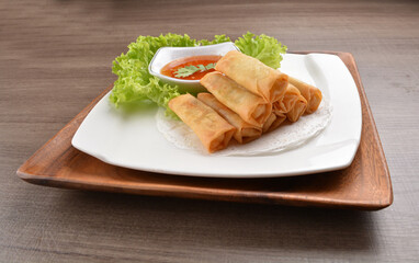 deep fried vegetable spring roll with Thai spicy chilli sauce on wood background asian halal vegan menu
