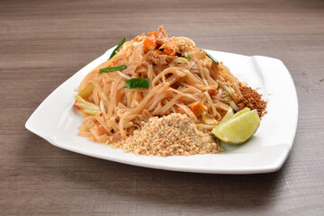 wok stir fried kway teow rice noodle mee goreng with vegetable in spicy soy chilli sauce on wood background asian halal vegan menu