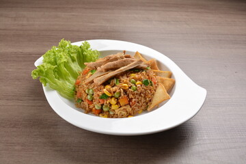 vegetarian nasi goreng fried rice with pineapple, vegetables meat in spicy chilli sambal sauce on wood background asian halal vegan menu