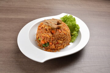 vegetarian nasi goreng fried rice with pineapple, vegetables meat in spicy chilli sambal sauce on wood background asian halal vegan menu