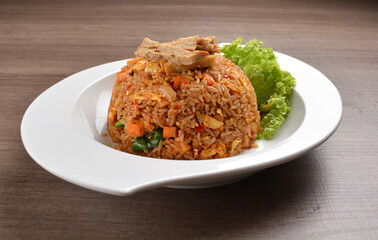vegetarian nasi goreng fried rice with pineapple, vegetables meat in spicy chilli sambal sauce on wood background asian halal vegan menu