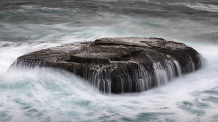 water flowing off a rock platform in the ocean