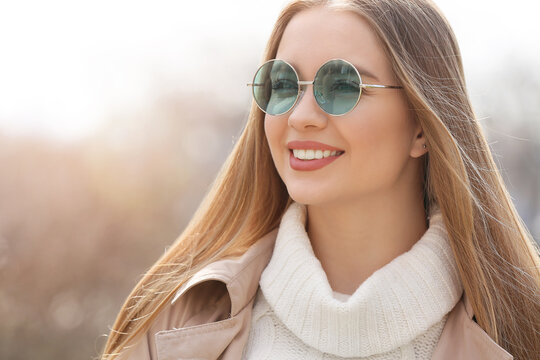 Young woman wearing stylish sunglasses outdoors