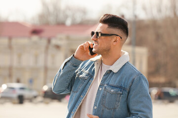 Young man talking by phone outdoors