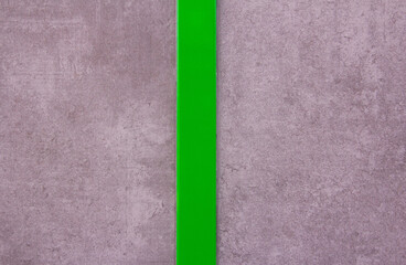 Fototapeta premium Gray wall texture with polished green stripe in the center. Background. Modern design.