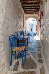 Traditional cycladitic alley with a whitewashed facades and an exterior of a cafe in chora Amorgos Greece