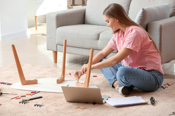 Young woman assembling furniture at home