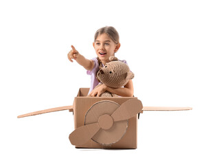 Little girl playing with toy and cardboard airplane on white background