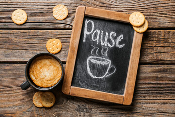 Cup of coffee with crackers and chalk board on wooden background - obrazy, fototapety, plakaty