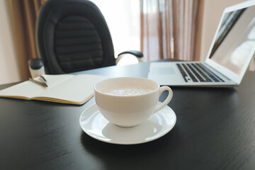 Cup of coffee on table in office, closeup
