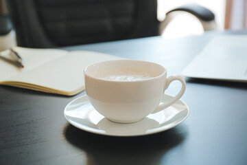 Cup of coffee on table in office, closeup