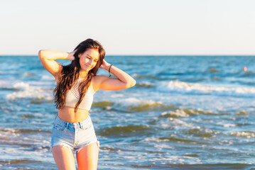 Fototapeta na wymiar Young woman playing in the sea.woman enjoying in sea water .Cheerful young woman having fun on the summer beach.