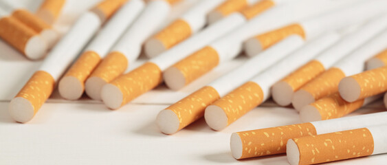 image of several commercially made pile cigarette on white  background. or Non smoking campaign concept, tobacco pattern top view.
