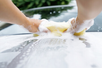 people worker man holding hand yellow sponge and bubble foam cleanser window for washing car. Concept car wash clean. Leave space for writing messages.
