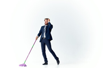 business man in a suit washes the floors with a mop manager