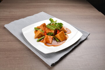 deep fried bean curd tofu with spicy sambal chilli sauce on wood background asian halal vegan menu