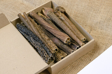 Full Cardboard Pet Treat Box on burlap fabric. Dried dog goodies