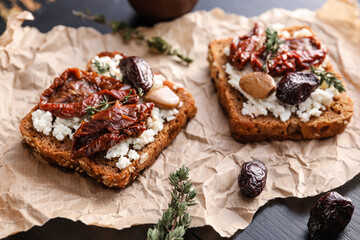 Tasty bruschettas with cheese, sun-dried tomatoes and dates, closeup