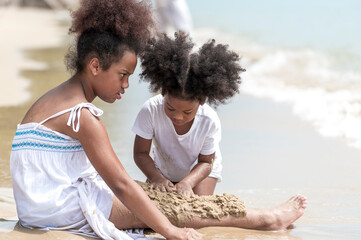 happy african american Little girl play and  buried in sand on the beach