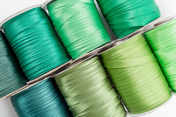top view of rolls with green decorative ribbons of different shades for clothes