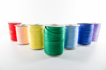 rolls with multi-colored decorative ribbons for clothes on a white background