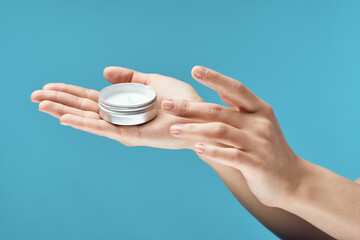 jar of cream in hands dermatology skin care cosmetics