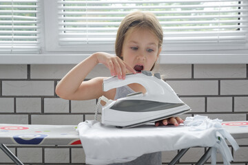 Screaming child with burned skin from iron. Hot iron burns the skin of the hands. child safety precautions