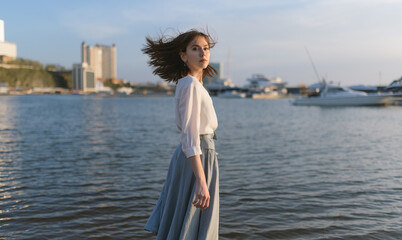 Woman in dress enjoys the sea shore.