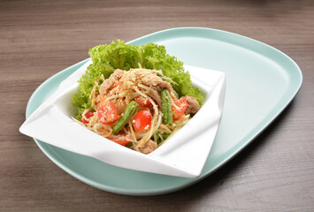 thai cold mango papaya vegetable salad in spicy sour lime sauce on wood background asian halal vegan menu