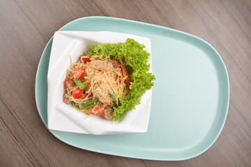 thai cold mango papaya vegetable salad in spicy sour lime sauce on wood background asian halal vegan menu